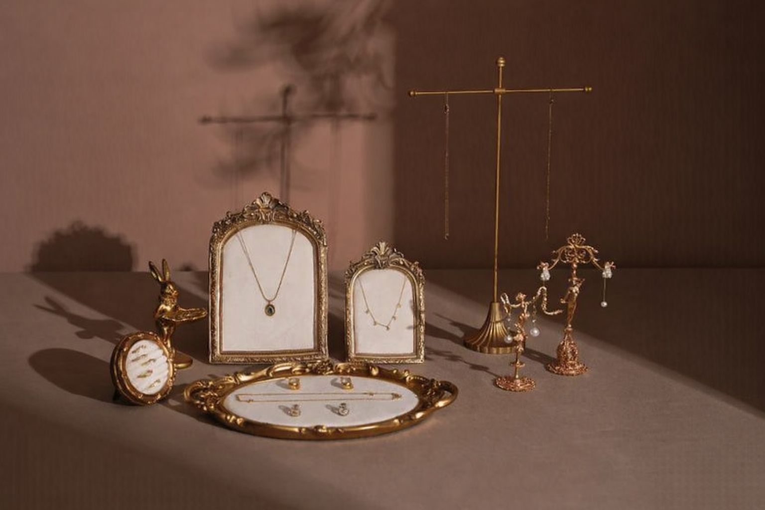 Antik smyckesdisplay med halsband och örhängen p&aring; ett bord.